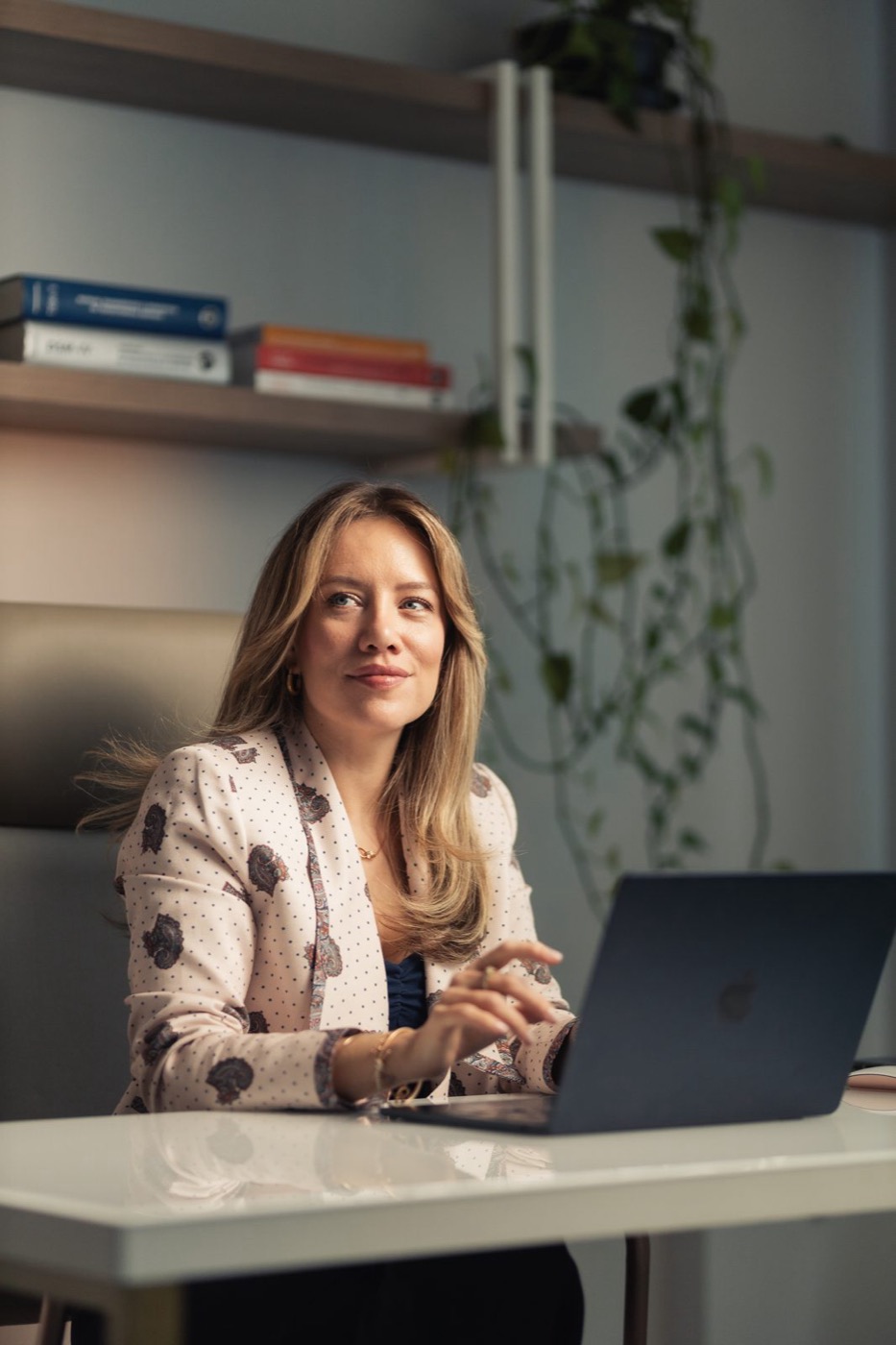 Lívia Oliveira trabalhando no computador em seu consultório